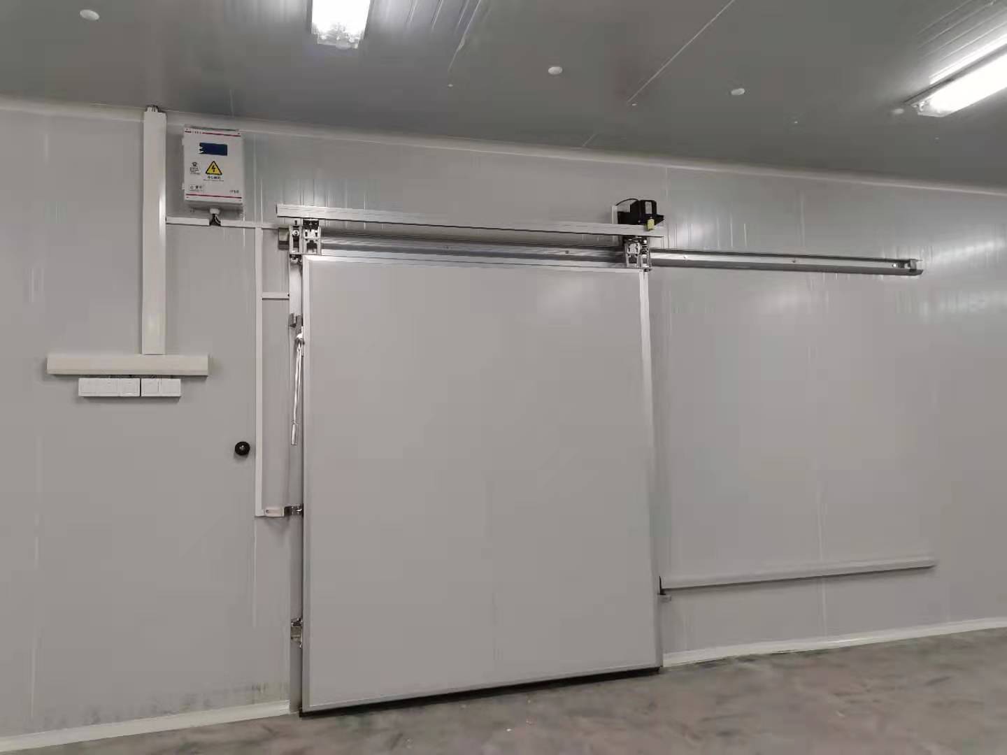 Electric sliding cold room door installed on insulated wall
