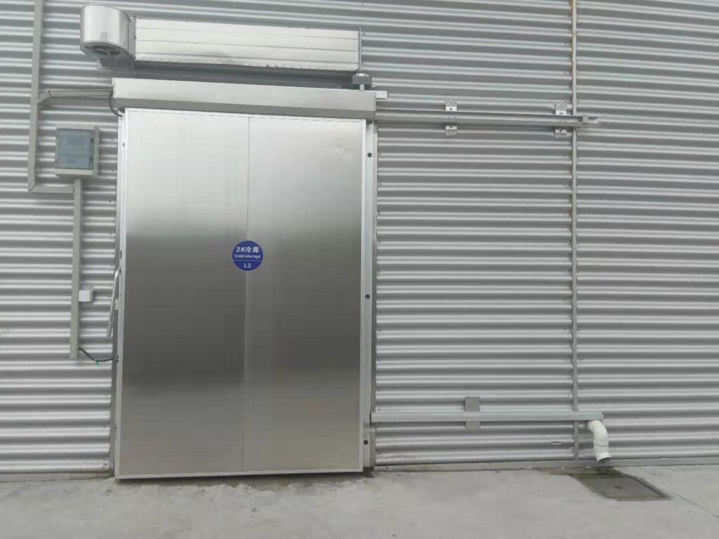 Cold room sliding door with automatic opener installed on steel wall
