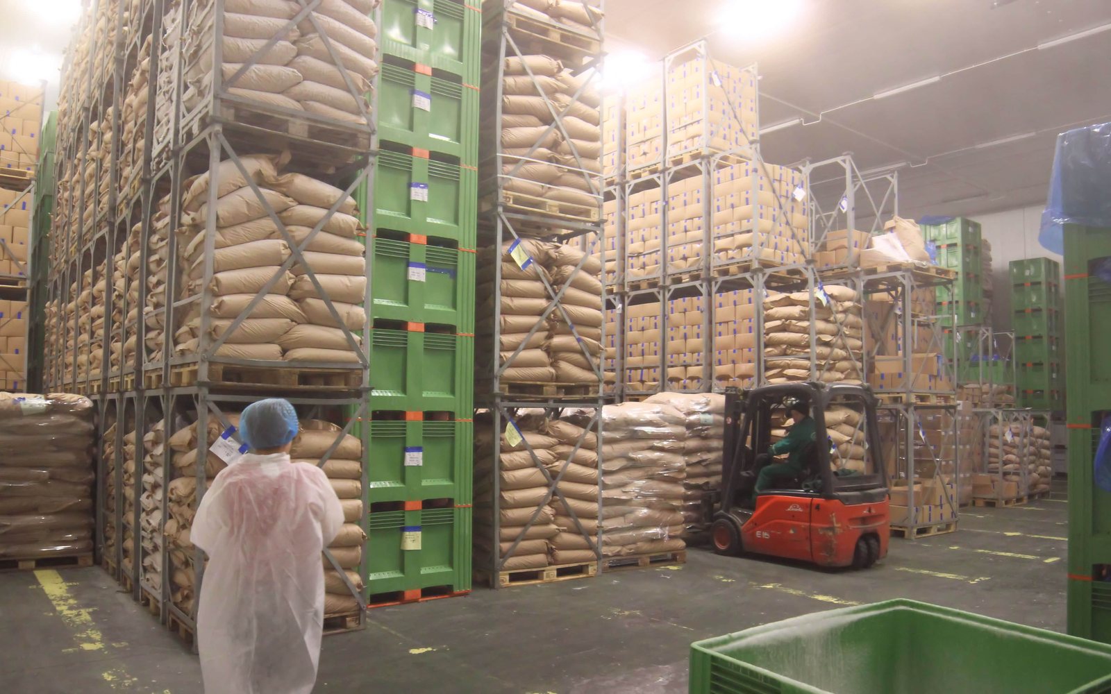 Fruit cold storage warehouse with stacked produce and forklift operation